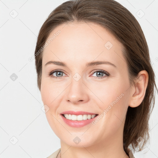 Joyful white young-adult female with medium  brown hair and grey eyes