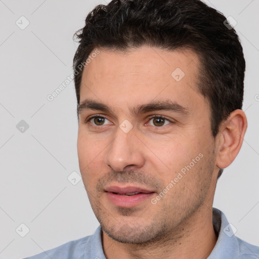 Joyful white young-adult male with short  black hair and brown eyes