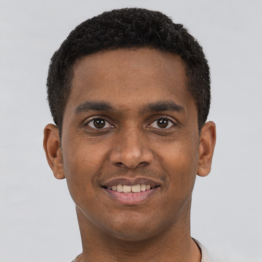 Joyful black young-adult male with short  brown hair and brown eyes