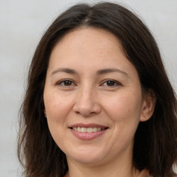 Joyful white adult female with long  brown hair and brown eyes