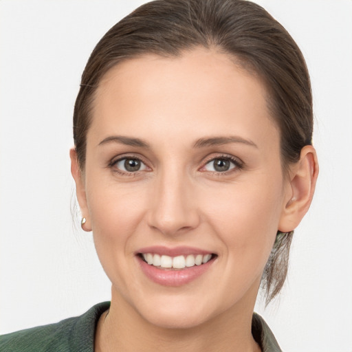 Joyful white young-adult female with medium  brown hair and grey eyes