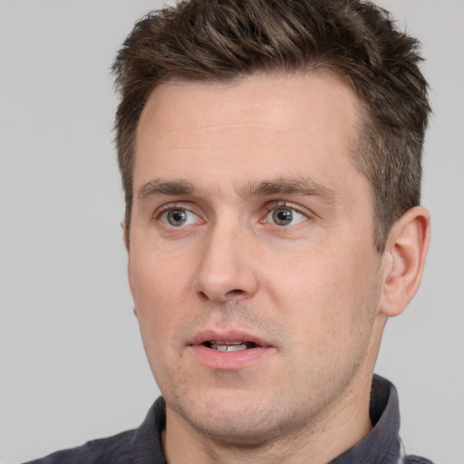 Joyful white adult male with short  brown hair and grey eyes