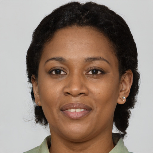 Joyful black adult female with short  brown hair and brown eyes