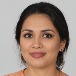 Joyful latino young-adult female with medium  brown hair and brown eyes