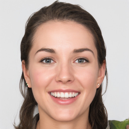 Joyful white young-adult female with medium  brown hair and grey eyes