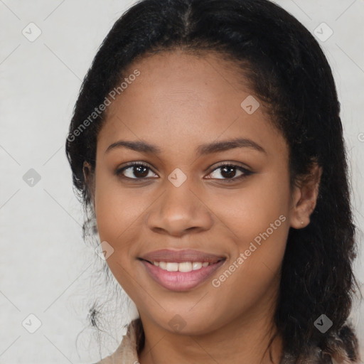 Joyful black young-adult female with long  brown hair and brown eyes