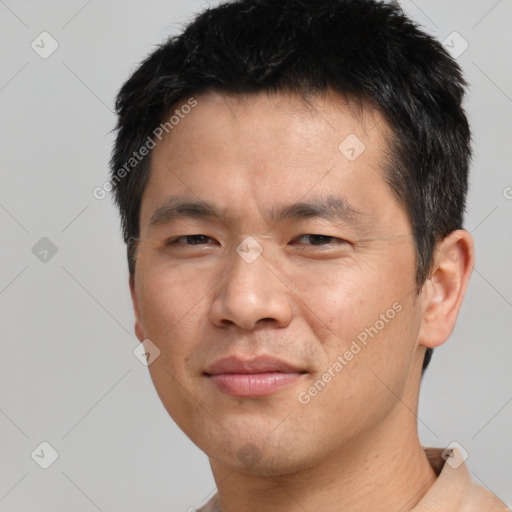 Joyful asian young-adult male with short  brown hair and brown eyes