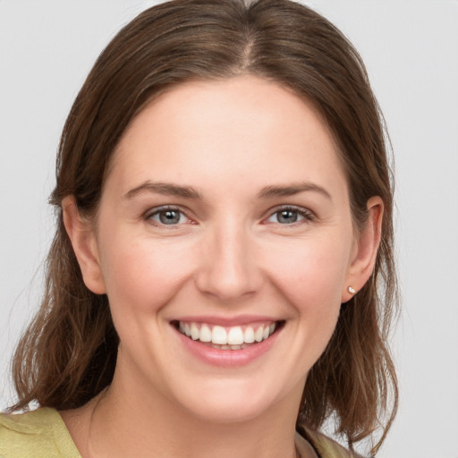 Joyful white young-adult female with medium  brown hair and grey eyes