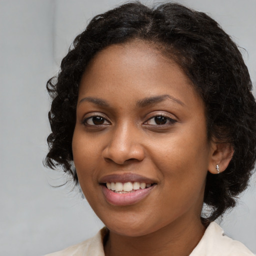 Joyful black young-adult female with medium  brown hair and brown eyes