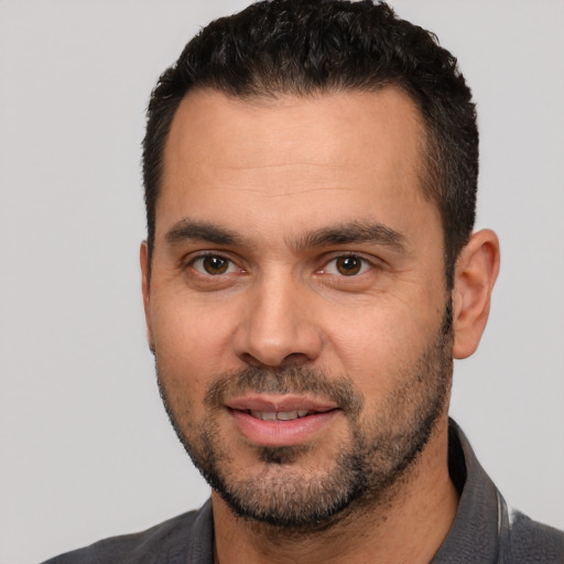 Joyful white young-adult male with short  black hair and brown eyes