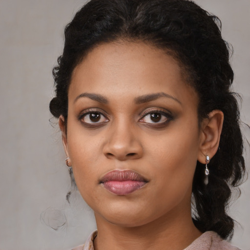 Joyful black young-adult female with long  brown hair and brown eyes