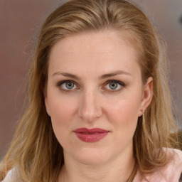 Joyful white young-adult female with long  brown hair and blue eyes