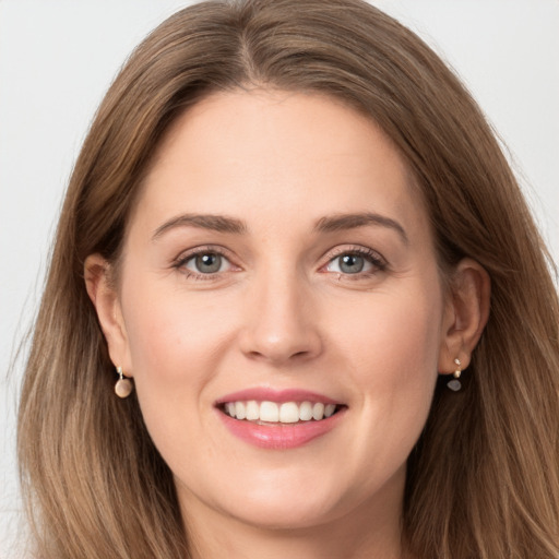 Joyful white young-adult female with long  brown hair and grey eyes