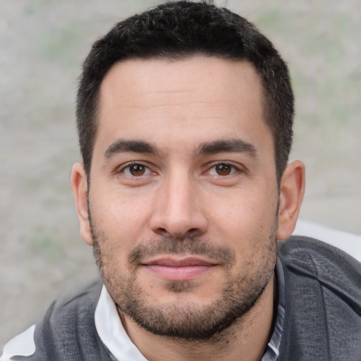 Joyful white young-adult male with short  black hair and brown eyes