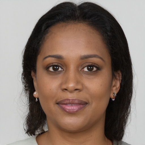 Joyful black young-adult female with medium  brown hair and brown eyes