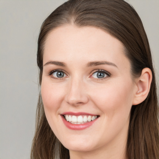 Joyful white young-adult female with long  brown hair and grey eyes