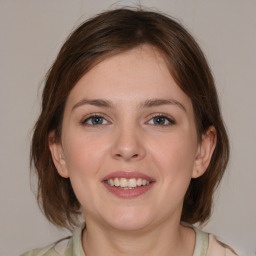 Joyful white young-adult female with medium  brown hair and grey eyes