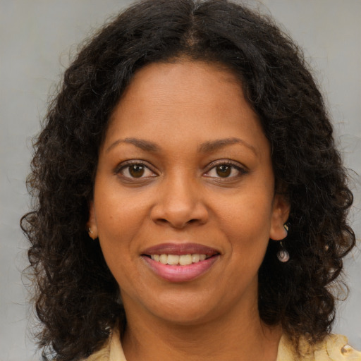 Joyful black young-adult female with medium  brown hair and brown eyes