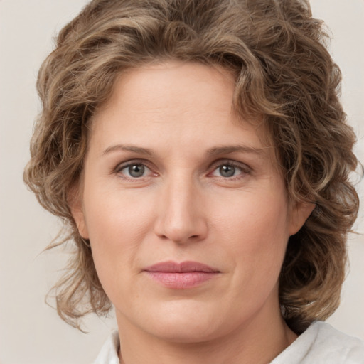 Joyful white young-adult female with medium  brown hair and green eyes