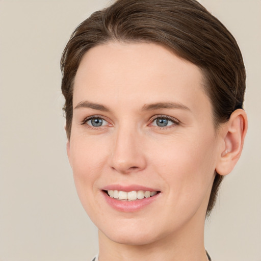 Joyful white young-adult female with short  brown hair and green eyes