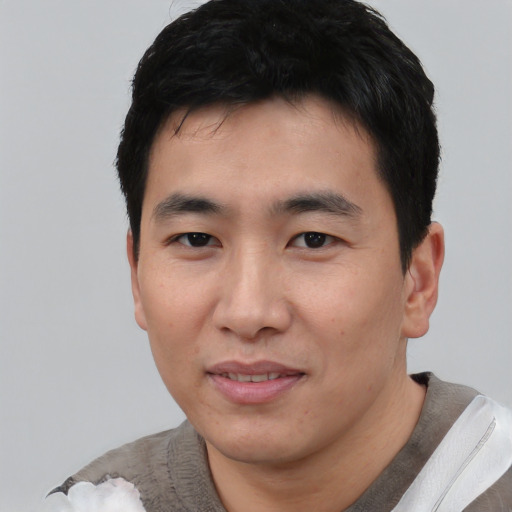 Joyful asian young-adult male with short  black hair and brown eyes