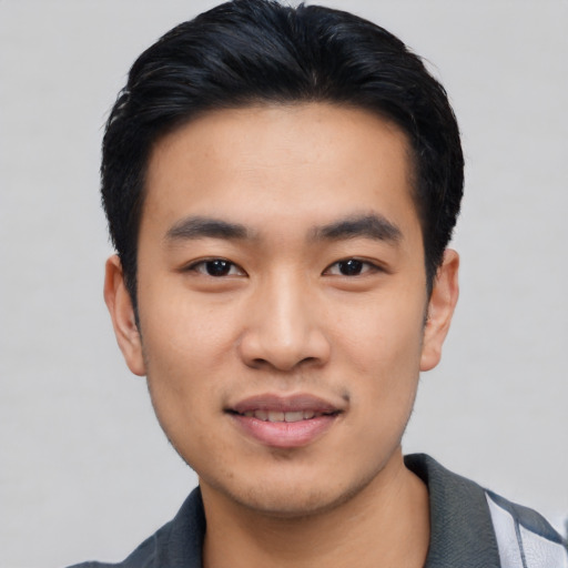 Joyful asian young-adult male with short  black hair and brown eyes