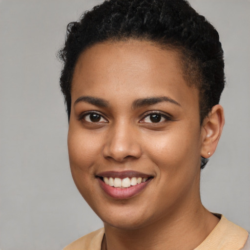 Joyful black young-adult female with short  brown hair and brown eyes