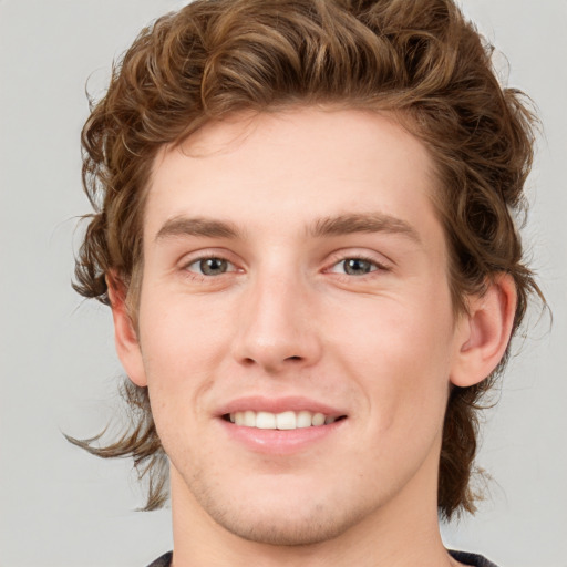 Joyful white young-adult male with medium  brown hair and blue eyes