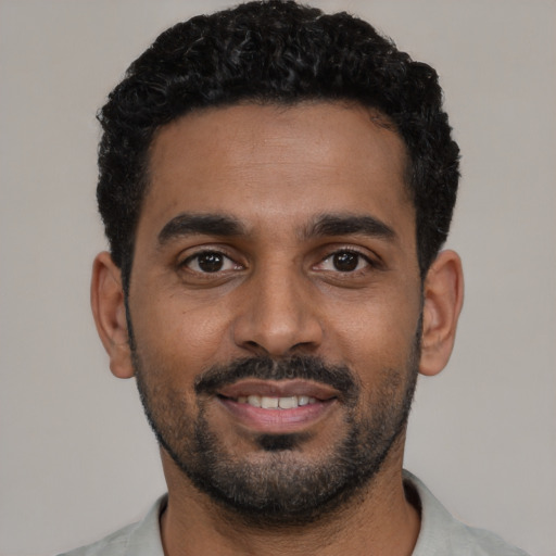 Joyful black young-adult male with short  black hair and brown eyes