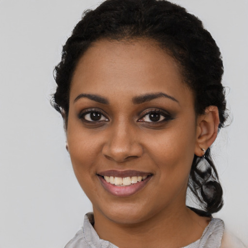 Joyful black young-adult female with long  black hair and brown eyes