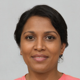 Joyful black adult female with medium  brown hair and brown eyes