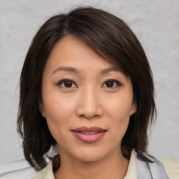 Joyful asian young-adult female with medium  brown hair and brown eyes