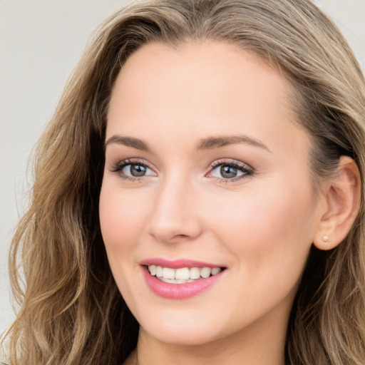 Joyful white young-adult female with long  brown hair and blue eyes