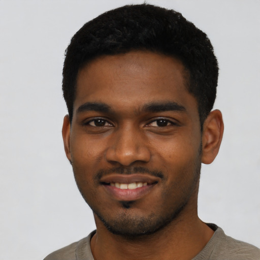Joyful black young-adult male with short  black hair and brown eyes