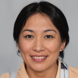 Joyful asian adult female with medium  brown hair and brown eyes