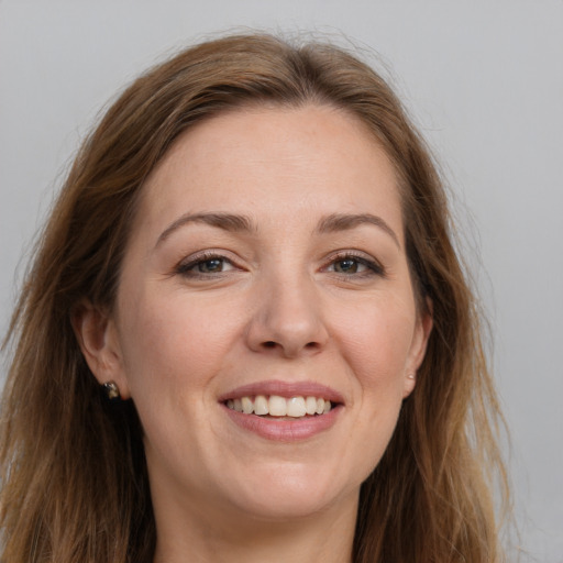Joyful white adult female with long  brown hair and grey eyes