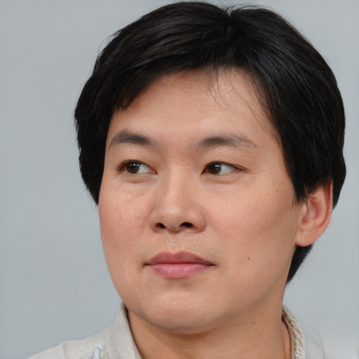 Joyful asian young-adult male with short  brown hair and brown eyes