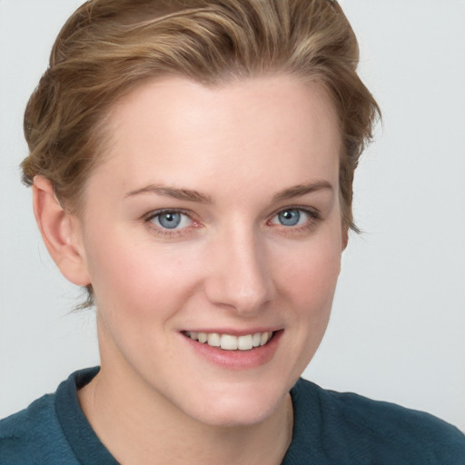 Joyful white young-adult female with short  brown hair and blue eyes