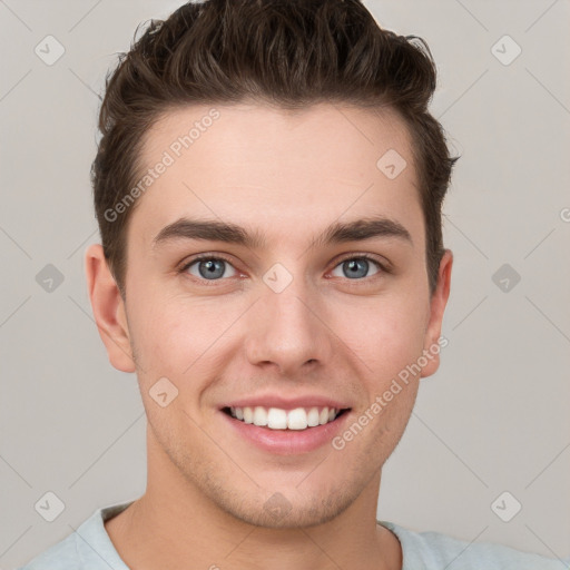 Joyful white young-adult male with short  brown hair and grey eyes