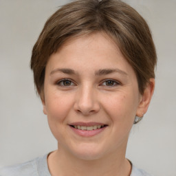 Joyful white young-adult female with short  brown hair and grey eyes