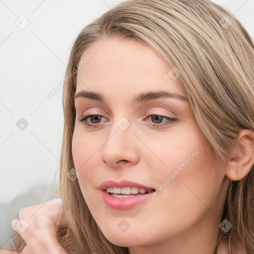 Joyful white young-adult female with long  brown hair and blue eyes