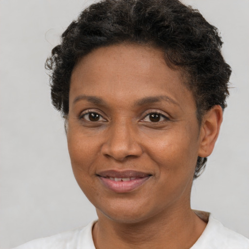 Joyful black adult female with short  brown hair and brown eyes