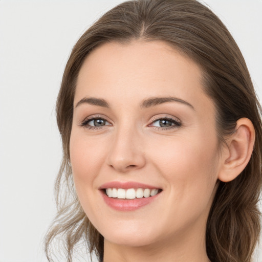 Joyful white young-adult female with long  brown hair and grey eyes