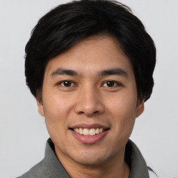 Joyful asian young-adult male with short  black hair and brown eyes