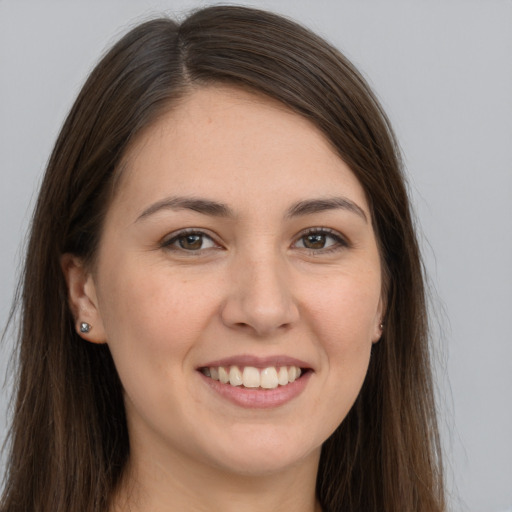 Joyful white young-adult female with long  brown hair and brown eyes