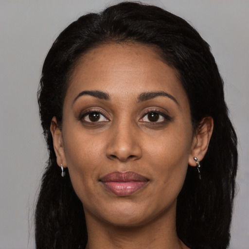 Joyful latino adult female with long  black hair and brown eyes