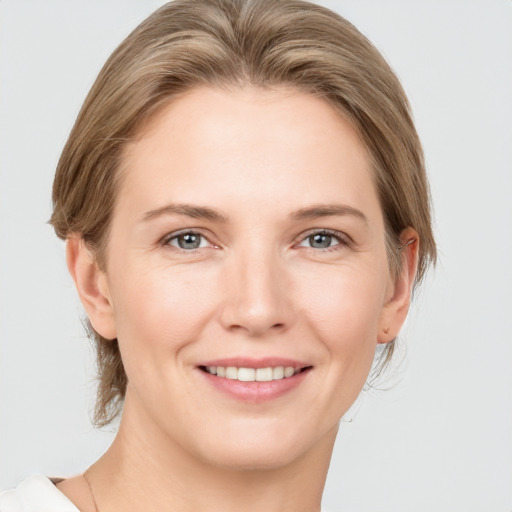 Joyful white young-adult female with medium  brown hair and grey eyes