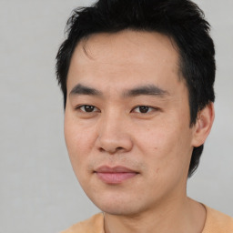 Joyful asian young-adult male with short  black hair and brown eyes