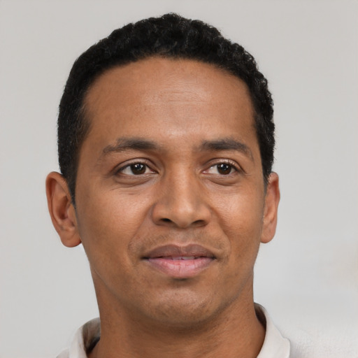Joyful black adult male with short  black hair and brown eyes