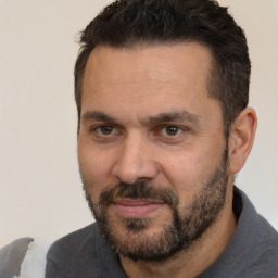 Joyful white adult male with short  brown hair and brown eyes